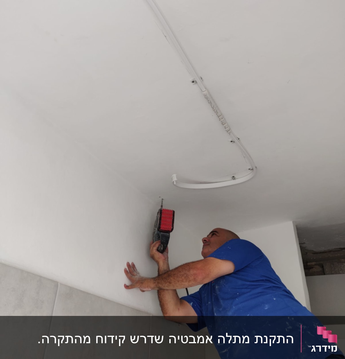 אדם קודח בתקרה עם מקדחה חשמלית